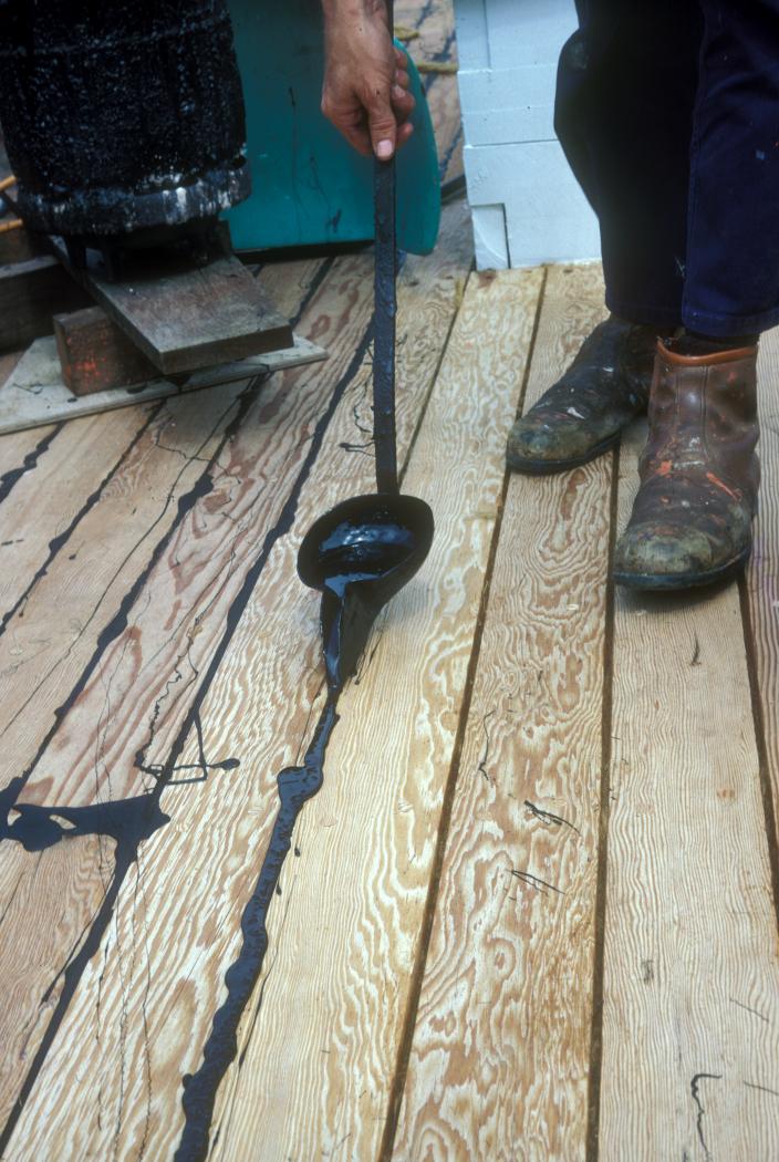Paying the deck seams with pitch after caulking on Trixen. 